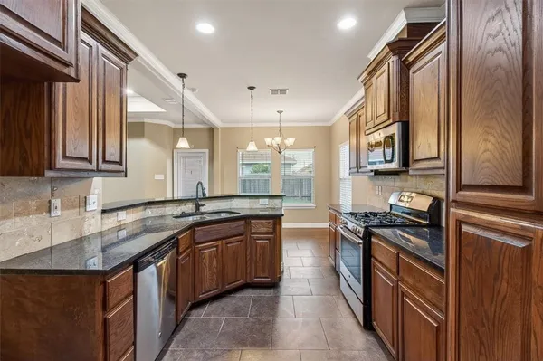 a kitchen with stainless steel appliances granite countertop a sink stove and cabinets