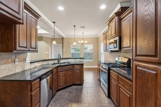 a kitchen with stainless steel appliances granite countertop a sink stove and cabinets