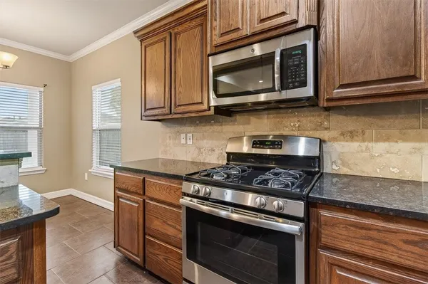 a kitchen with stainless steel appliances granite countertop a stove microwave and cabinets