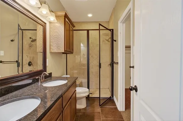 a bathroom with a granite countertop sink a toilet and a mirror