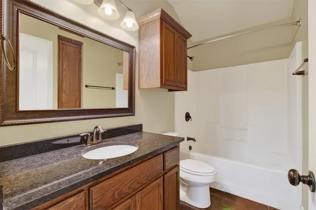 a bathroom with a granite countertop sink a mirror and a shower