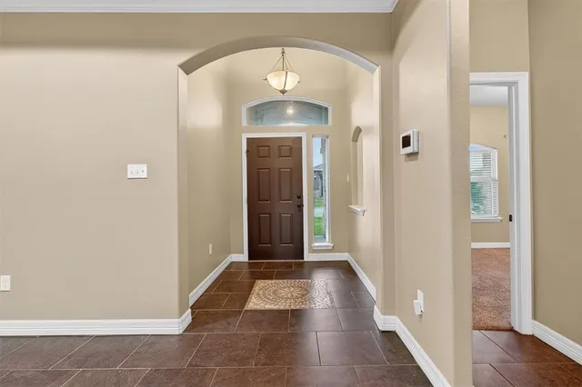 a view of a hallway with wooden floor and a chandelier
