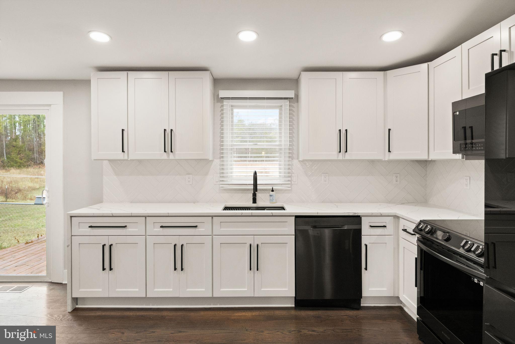 14068 Carriage Ford Road Nokesville, VA 20181 - Photo 16 of 48 a kitchen with white cabinets and appliances