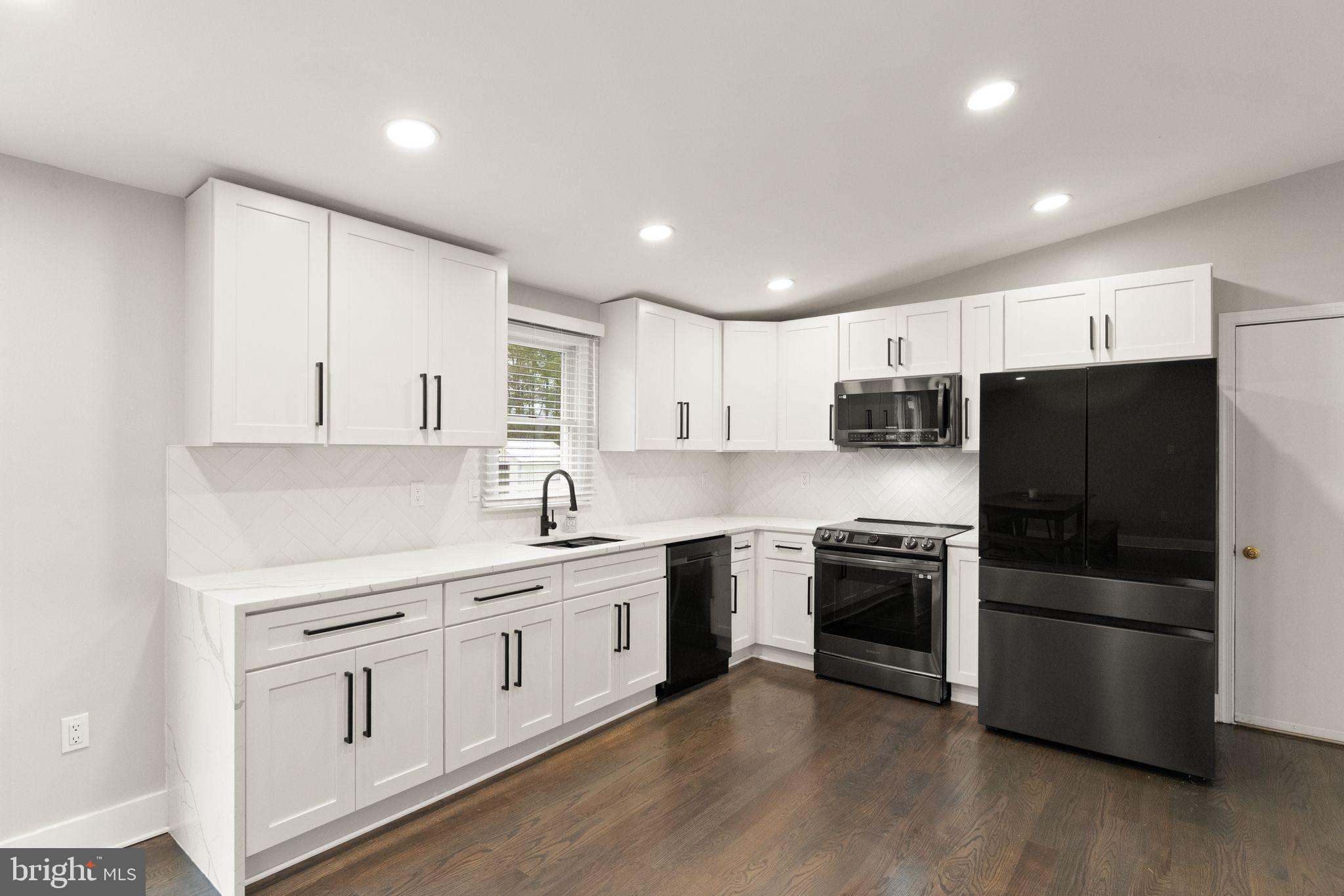 14068 Carriage Ford Road Nokesville, VA 20181 - Photo 17 of 48 a kitchen with white cabinets and stainless steel appliances
