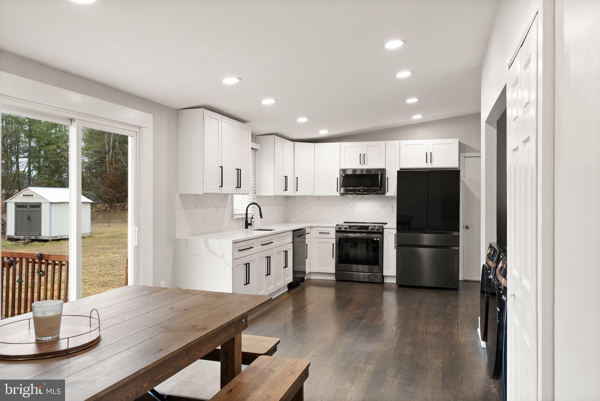 14068 Carriage Ford Road Nokesville, VA 20181 - Photo 19 of 48 a kitchen with stainless steel appliances granite countertop a refrigerator a stove top oven a sink dishwasher and white cabinets with wooden floor