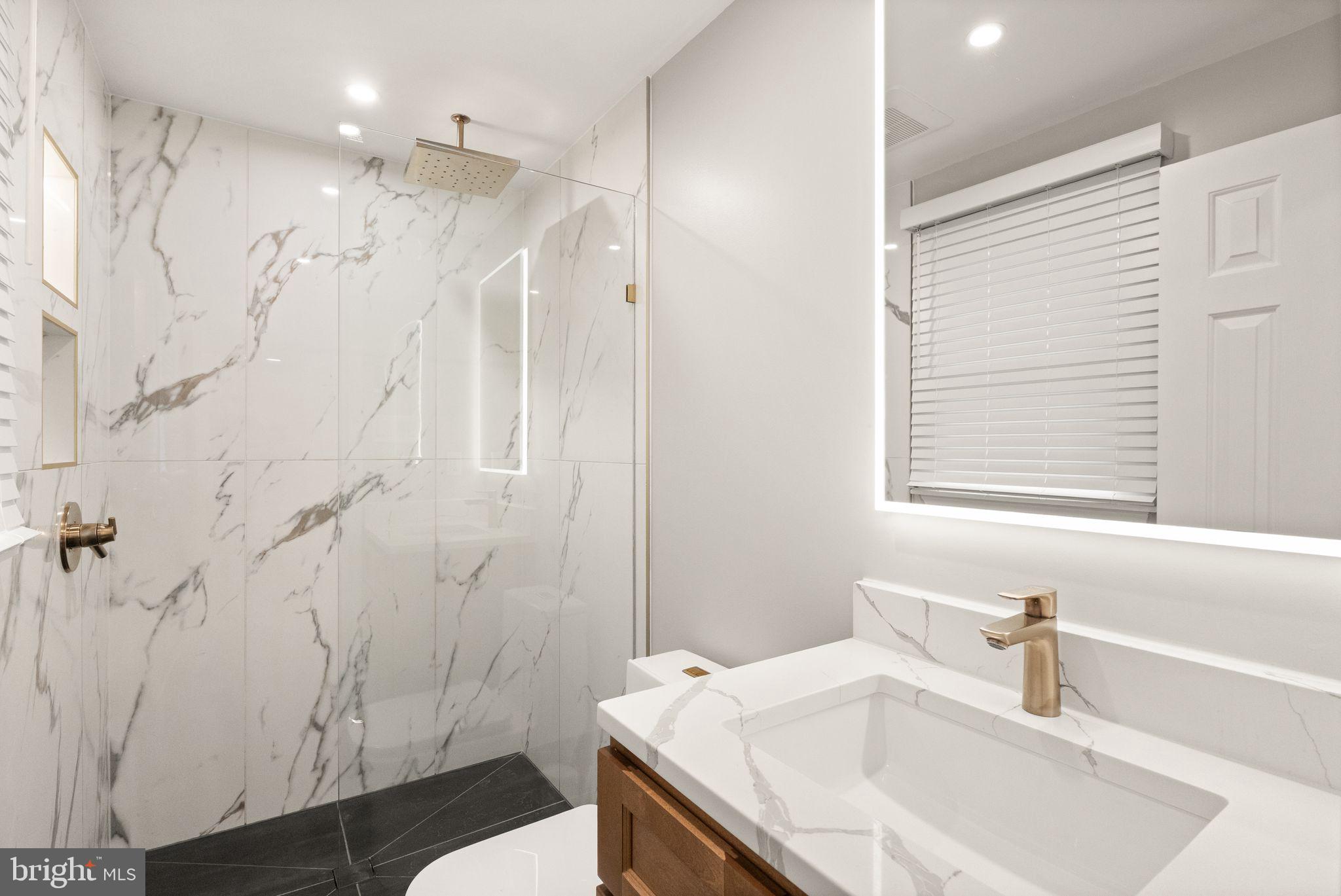14068 Carriage Ford Road Nokesville, VA 20181 - Photo 25 of 48 a bathroom with a granite countertop sink a toilet a shower and a mirror