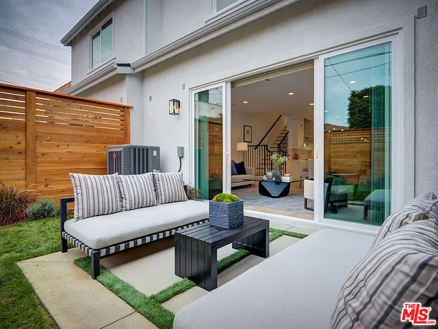 a view of living room kitchen with patio furniture and garden