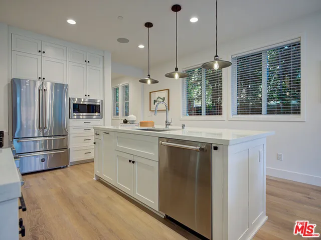a kitchen with stainless steel appliances a refrigerator sink and cabinets