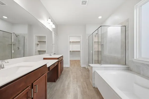 a spacious bathroom with a granite countertop tub sink shower and mirror