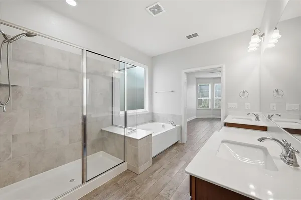 a bathroom with a double vanity sink a mirror and a bathtub