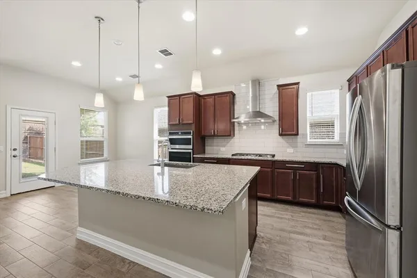 a kitchen with stainless steel appliances granite countertop a sink refrigerator and microwave