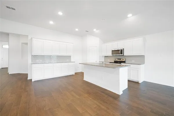 a kitchen with white cabinets and appliances