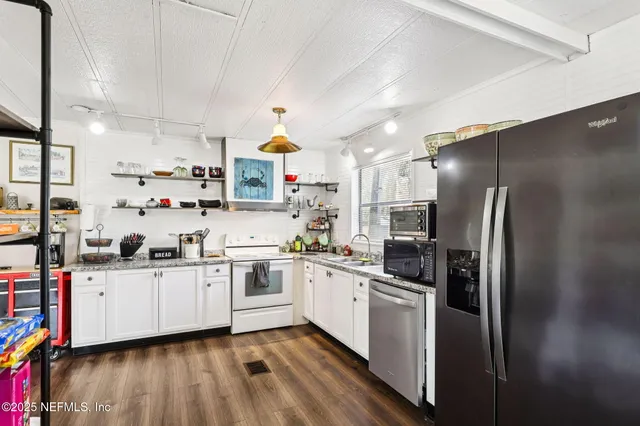 a kitchen with stainless steel appliances a sink a stove a refrigerator and cabinets