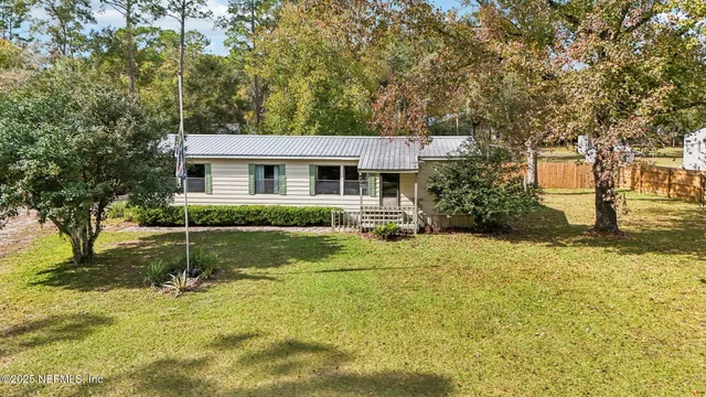 a view of a house with a yard and sitting area