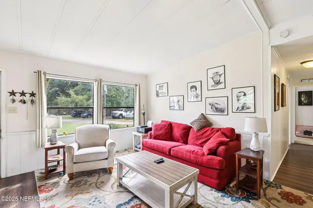 a living room with furniture a large window and a rug