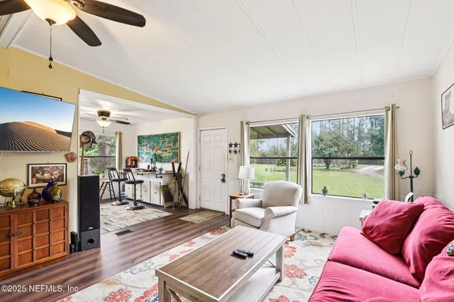 a living room with furniture and a floor to ceiling window