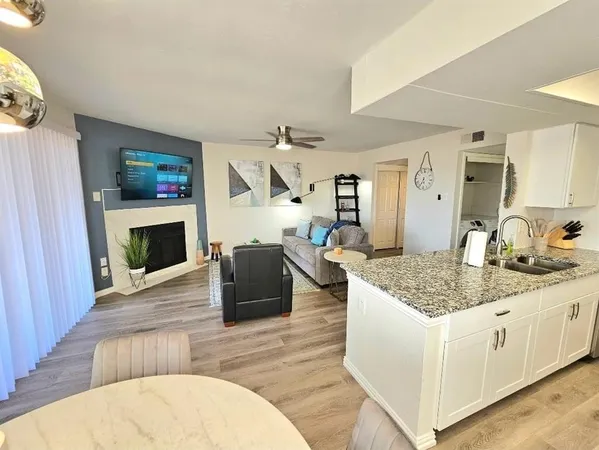 a living room with granite countertop furniture a fireplace and a flat screen tv