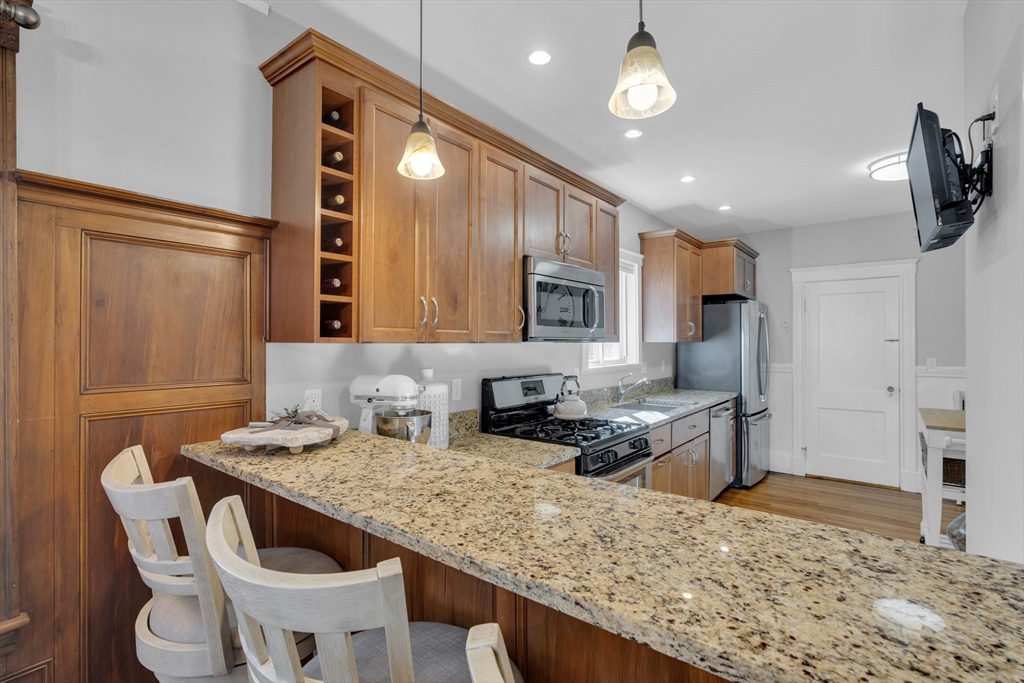 173 Train Street, Unit 1 Boston, MA 02122 - Photo 4 of 13 a kitchen with stainless steel appliances granite countertop a sink and a refrigerator