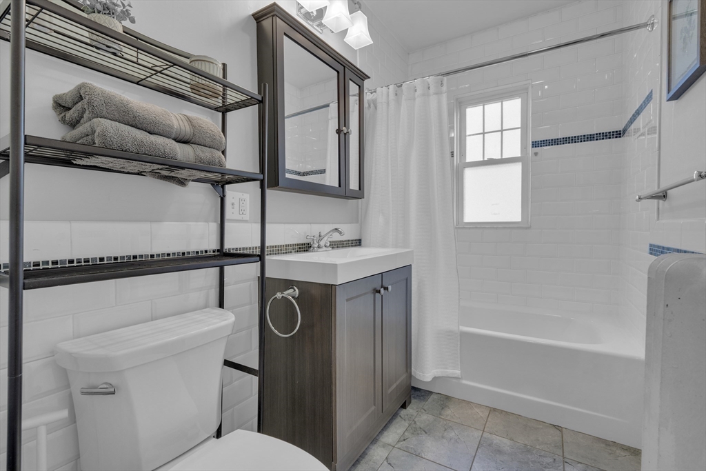 173 Train Street, Unit 1 Boston, MA 02122 - Photo 10 of 13 a bathroom with a granite countertop sink toilet and shower