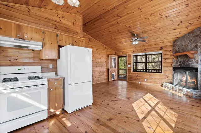 a kitchen with a refrigerator a stove cabinets and wooden floor