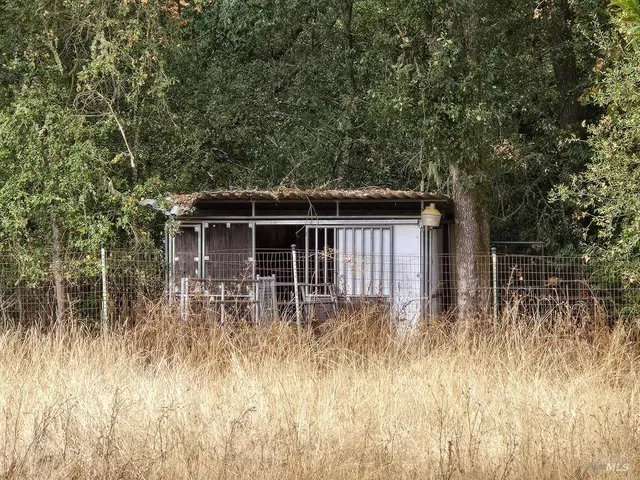 a view of a backyard with table and chairs under an umbrella