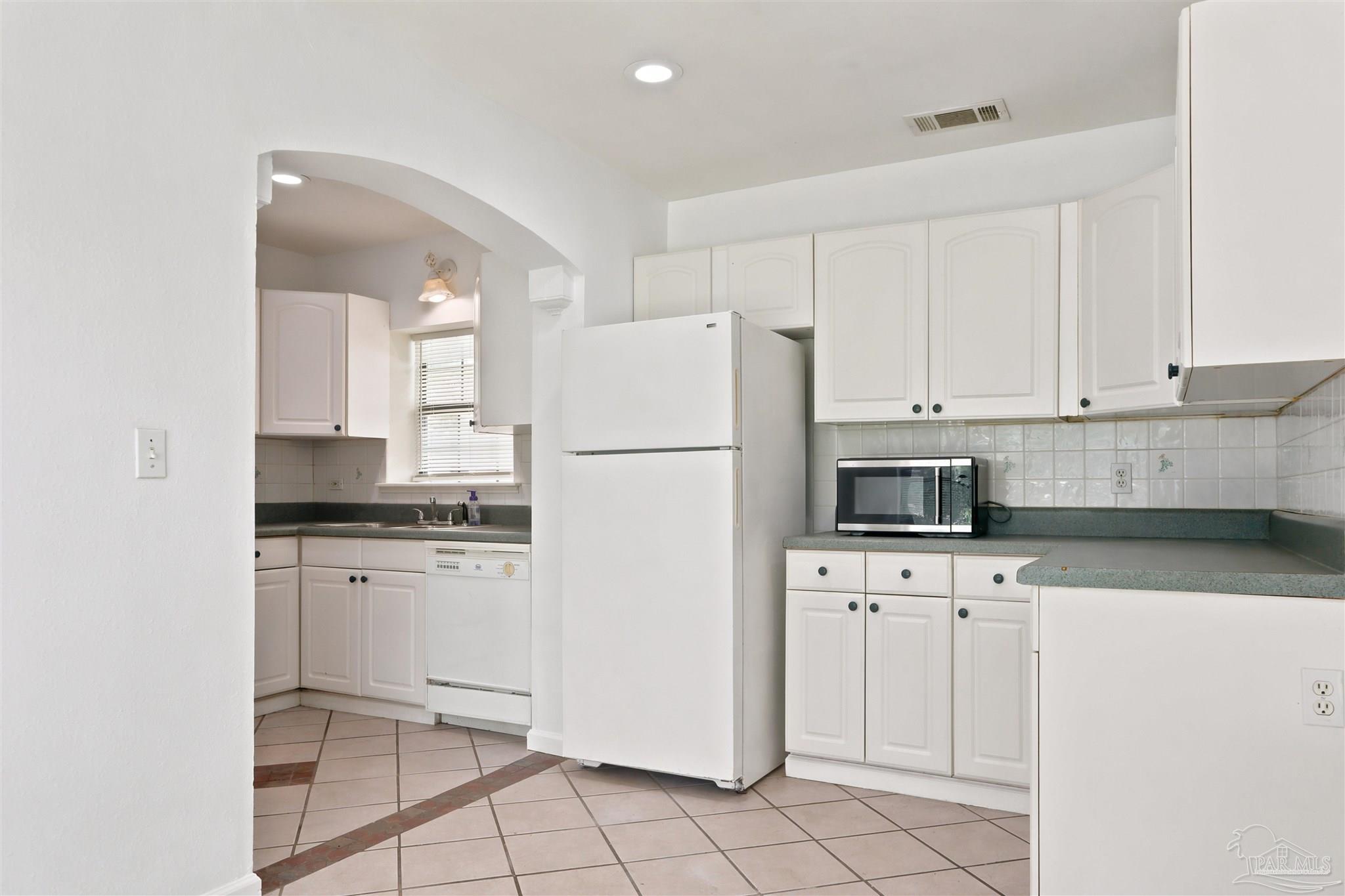 101 Vanderbilt Road Pensacola, FL 32506 - Photo 10 of 33 Kitchen, white cabinets and arch