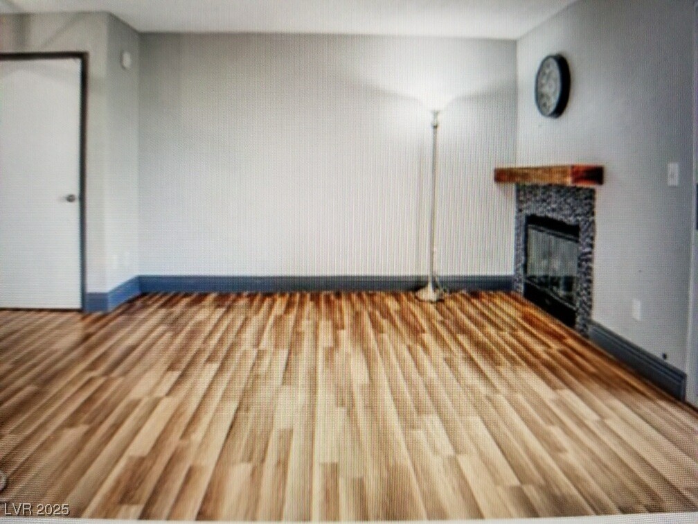 3150 North Soft Breezes Drive, Unit 1033 Las Vegas, NV 89128 - Photo 2 of 14 Unfurnished living room featuring a fireplace, woo