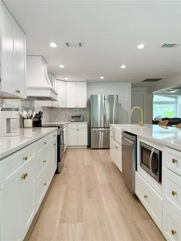 a large kitchen with stainless steel appliances lots of counter space sink and cabinets