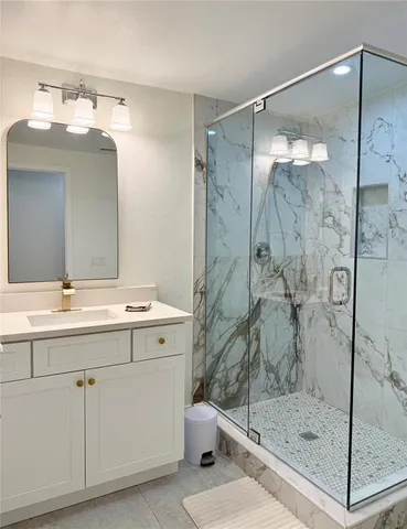 a bathroom with a shower sink and mirror