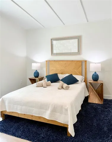 a bedroom with a bed and a lamp with the wooden floor