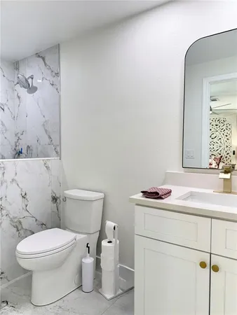 a bathroom with a sink toilet and mirror