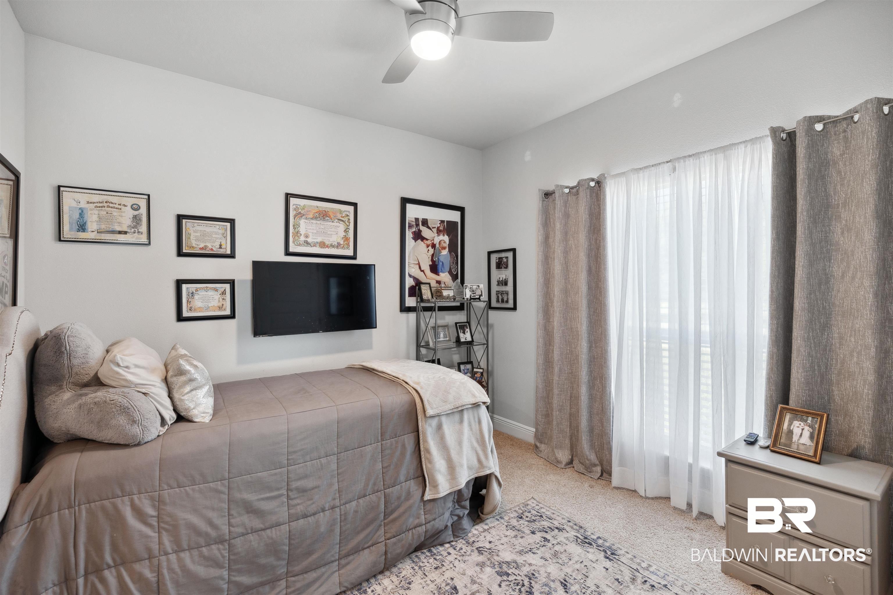 23809 Devonfield Lane Daphne, AL 36526 - Photo 26 of 29 Bedroom with baseboards, ceiling fan, multiple windows, and light carpet