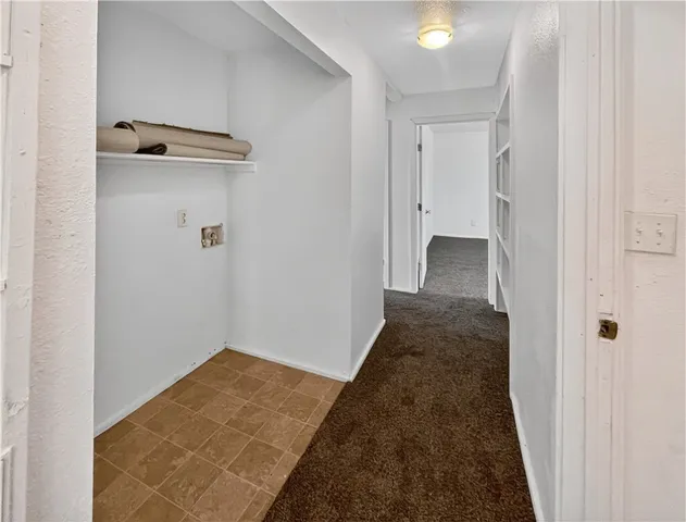 a view of a hallway with wooden floor and closet