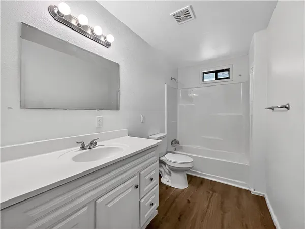 a bathroom with a sink a toilet a shower and a mirror
