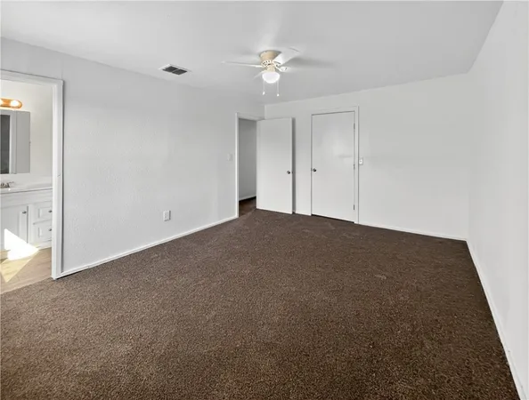 an empty room with a ceiling fan and a window