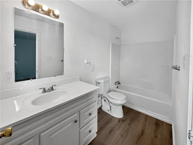 a bathroom with a granite countertop toilet a sink and a bathtub