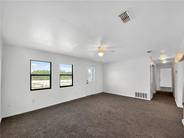 an empty room with windows and closet