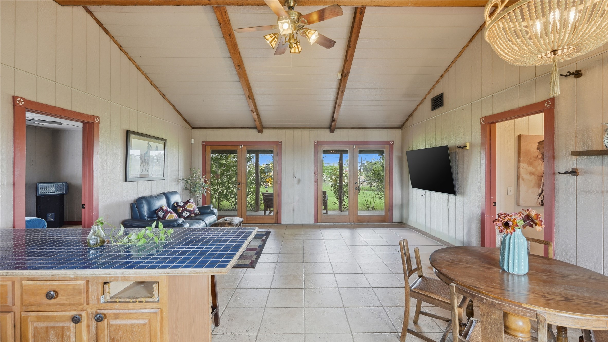 127 Offer Llano, TX 78643 - Photo 24 of 40 Spacious room featuring vaulted ceilings with exposed wood beams, tile flooring, and light-toned vertical paneling