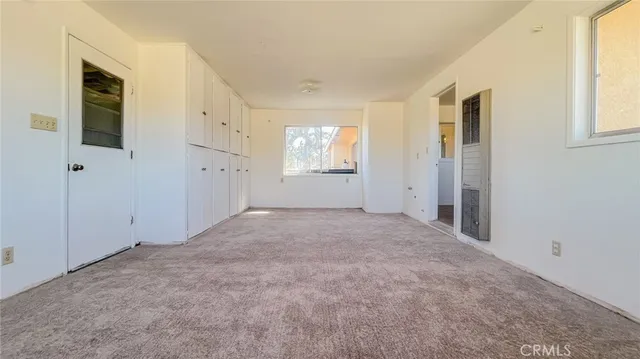 an empty room with windows and closet