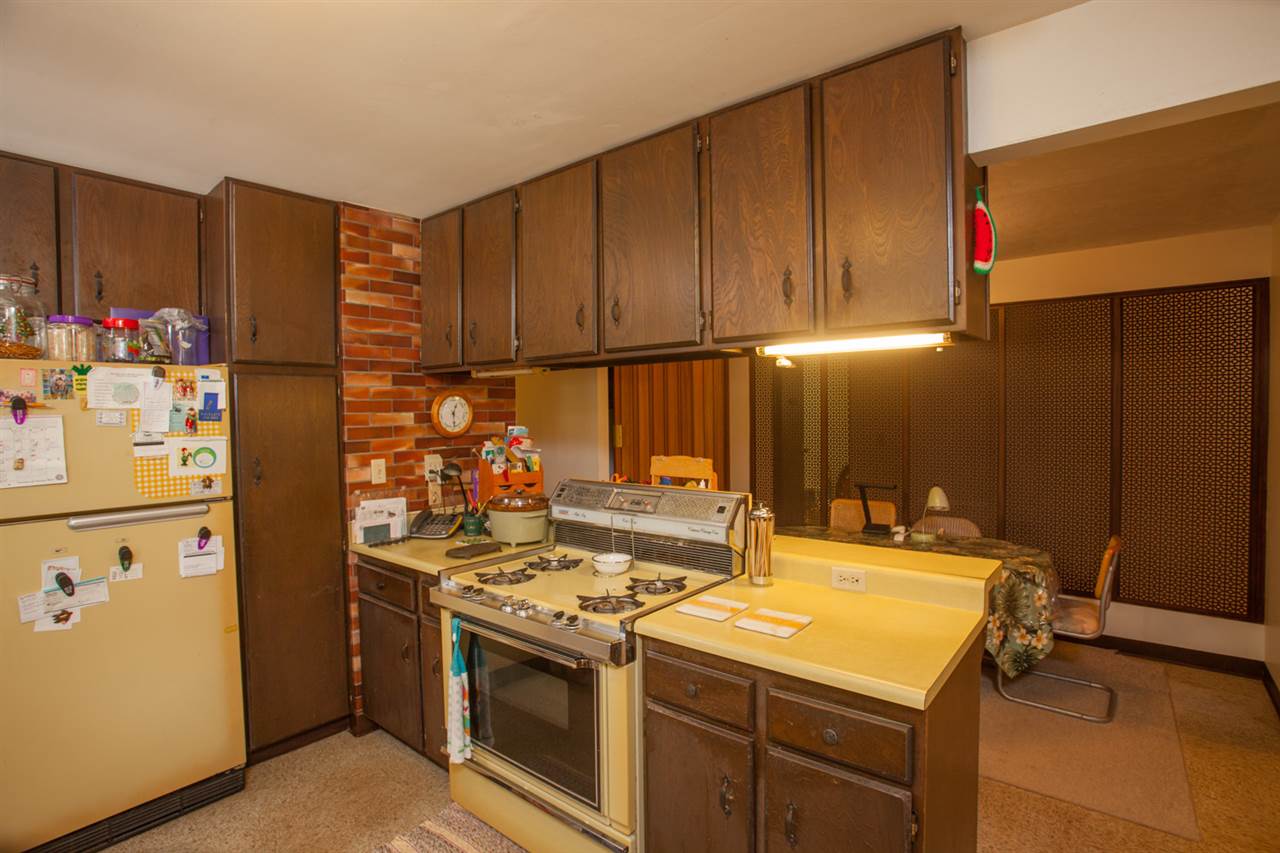 605 Kaupakalua Road Haiku, HI 96708 - Photo 13 of 30 a kitchen with stainless steel appliances granite countertop a stove a refrigerator and a wooden cabinets