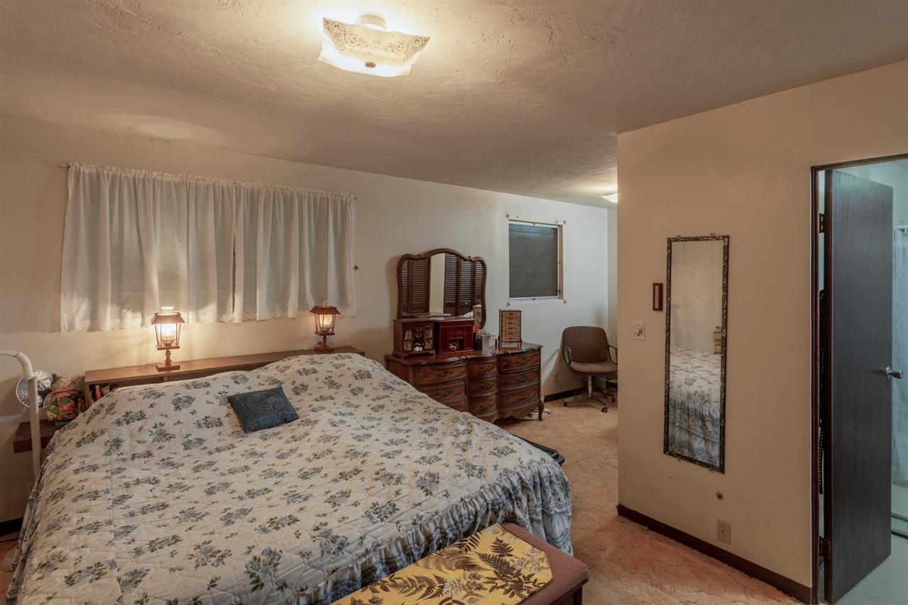 605 Kaupakalua Road Haiku, HI 96708 - Photo 18 of 30 a bedroom with a bed and dresser with mirror