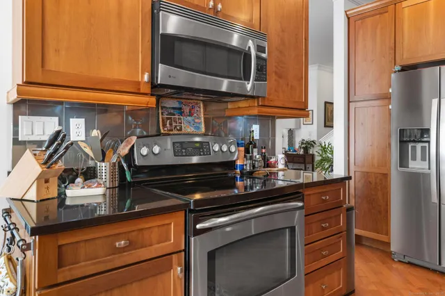 a kitchen with stainless steel appliances granite countertop a stove and a microwave