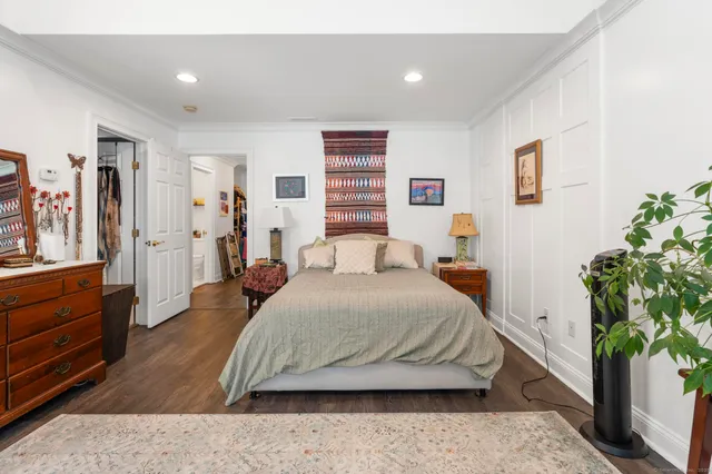 a bedroom with a large bed and potted plant