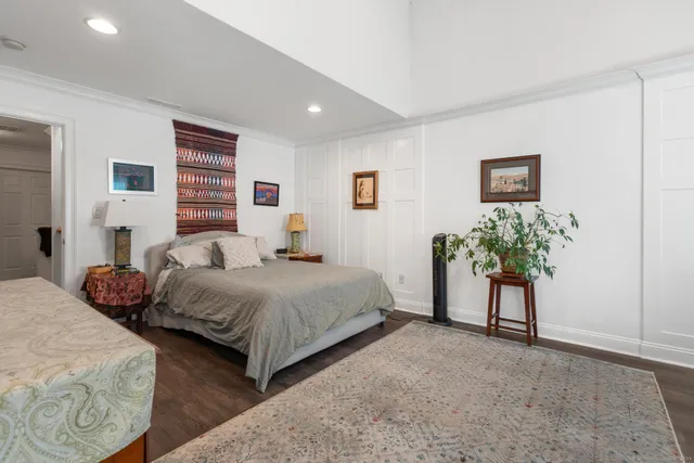 a bedroom with a bed and a potted plant