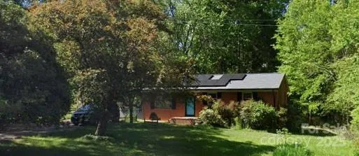 front view of a house with a yard and a tree