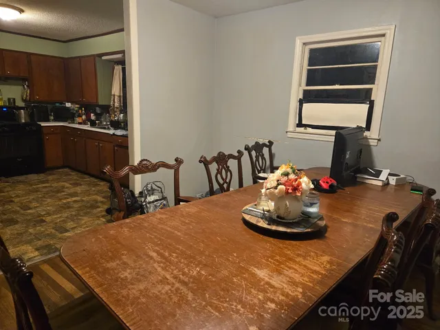 a room with a table chairs and kitchen view