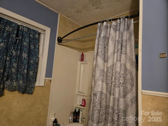 a bathroom with a shower curtain and a window