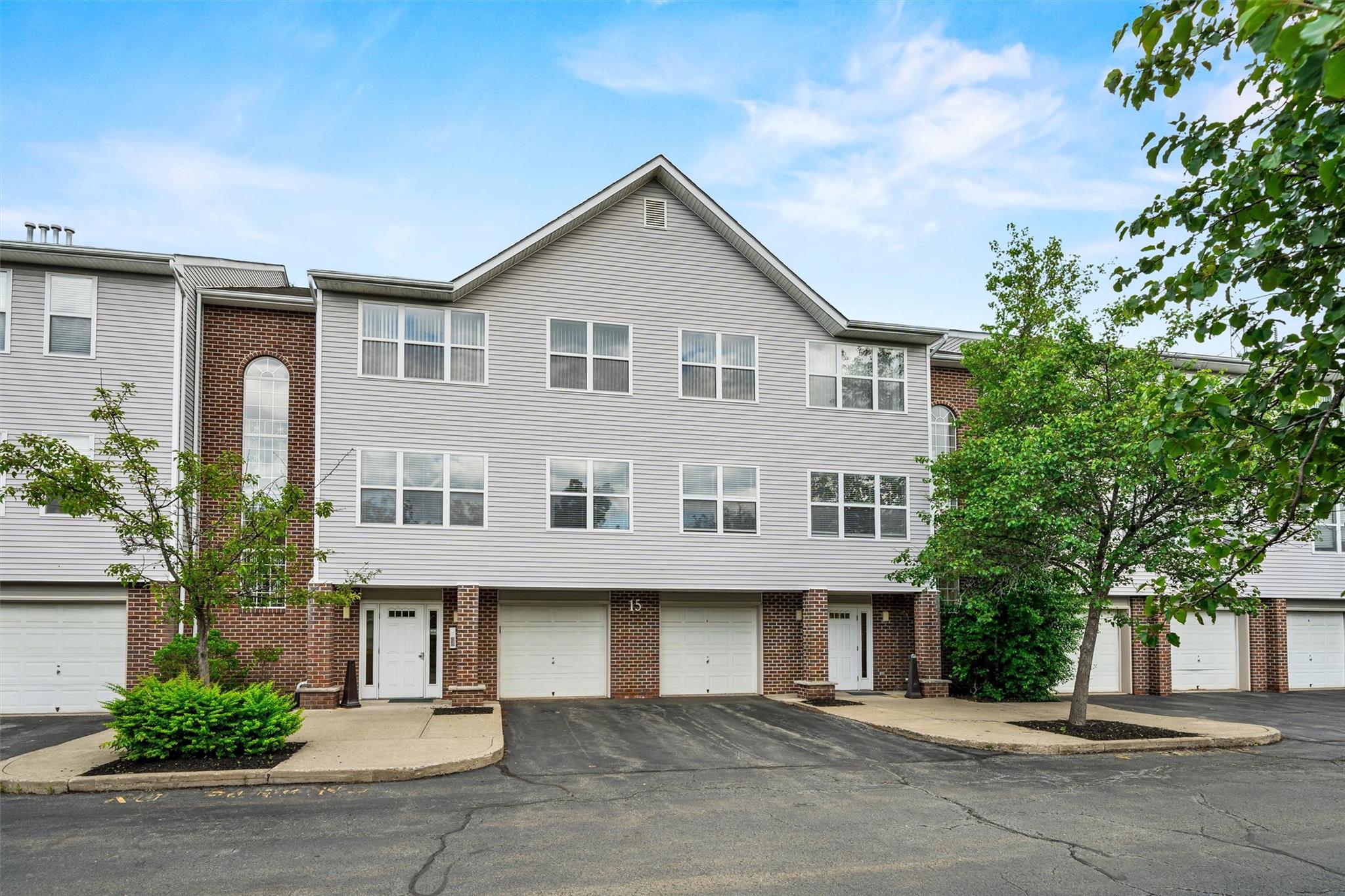 a view of a white house with a large windows and plants