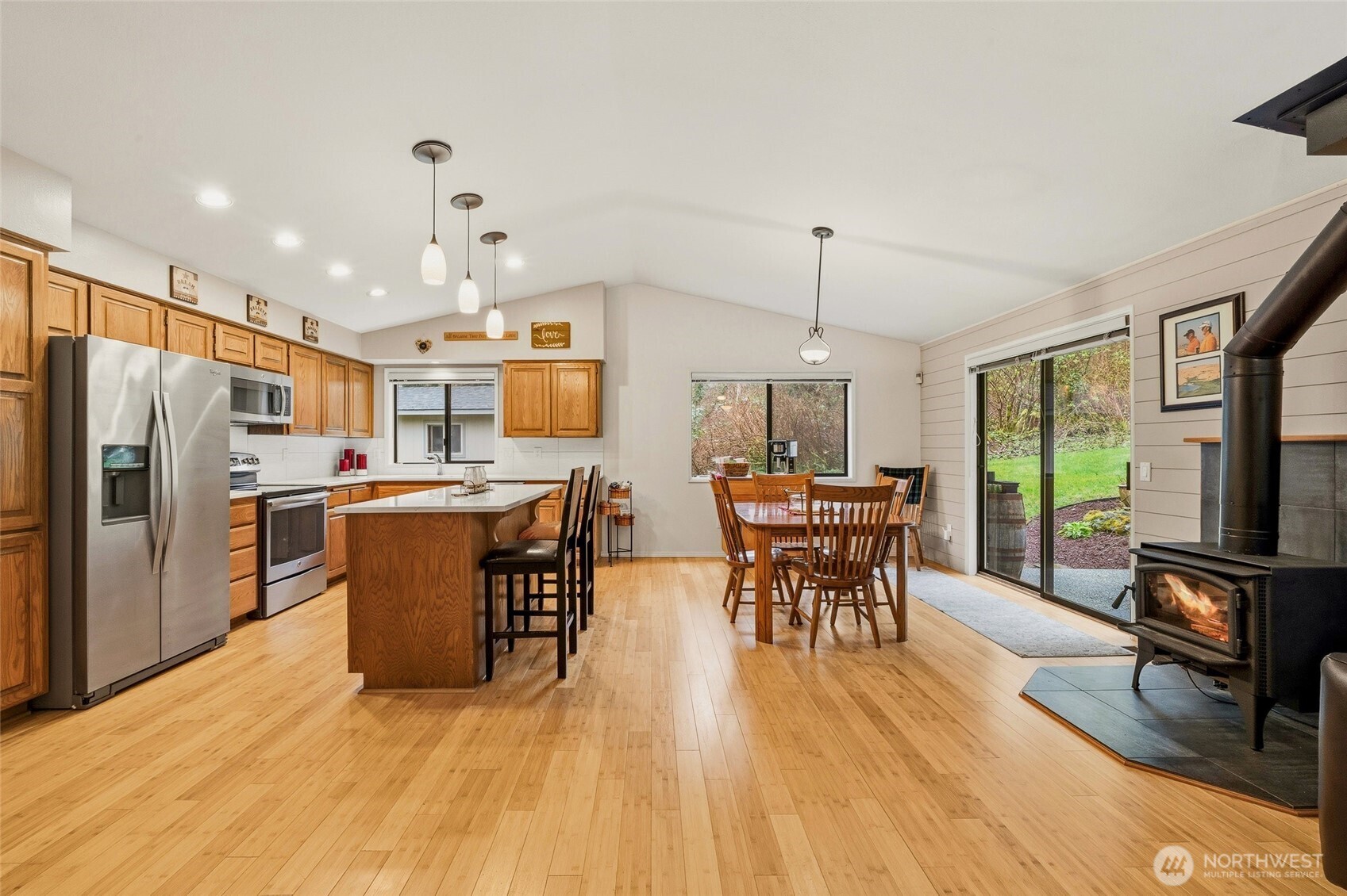 6830 Norma Beach Road Edmonds, WA 98026 - Photo 3 of 30 a kitchen with stainless steel appliances granite countertop a refrigerator a stove top oven a sink dishwasher a dining table and chairs with wooden floor