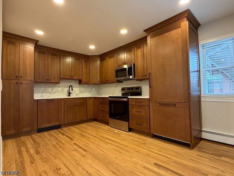 93 Centre Street Nutley, NJ 07110 - Photo 2 of 8 a kitchen with stainless steel appliances granite countertop a refrigerator sink and cabinets